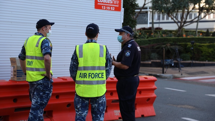 Two Air Force personnel chat to a police officer.