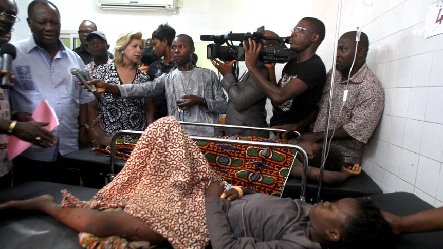 Alassane Ouattara and wife, Dominique, visit a stampede victim in hospital.