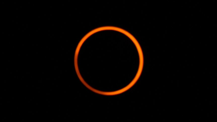The sun forms a bright ring behind a darkened moon during an annular solar eclipse