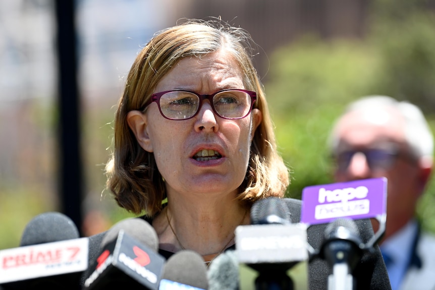 Woman wearing glasses behind the microphone