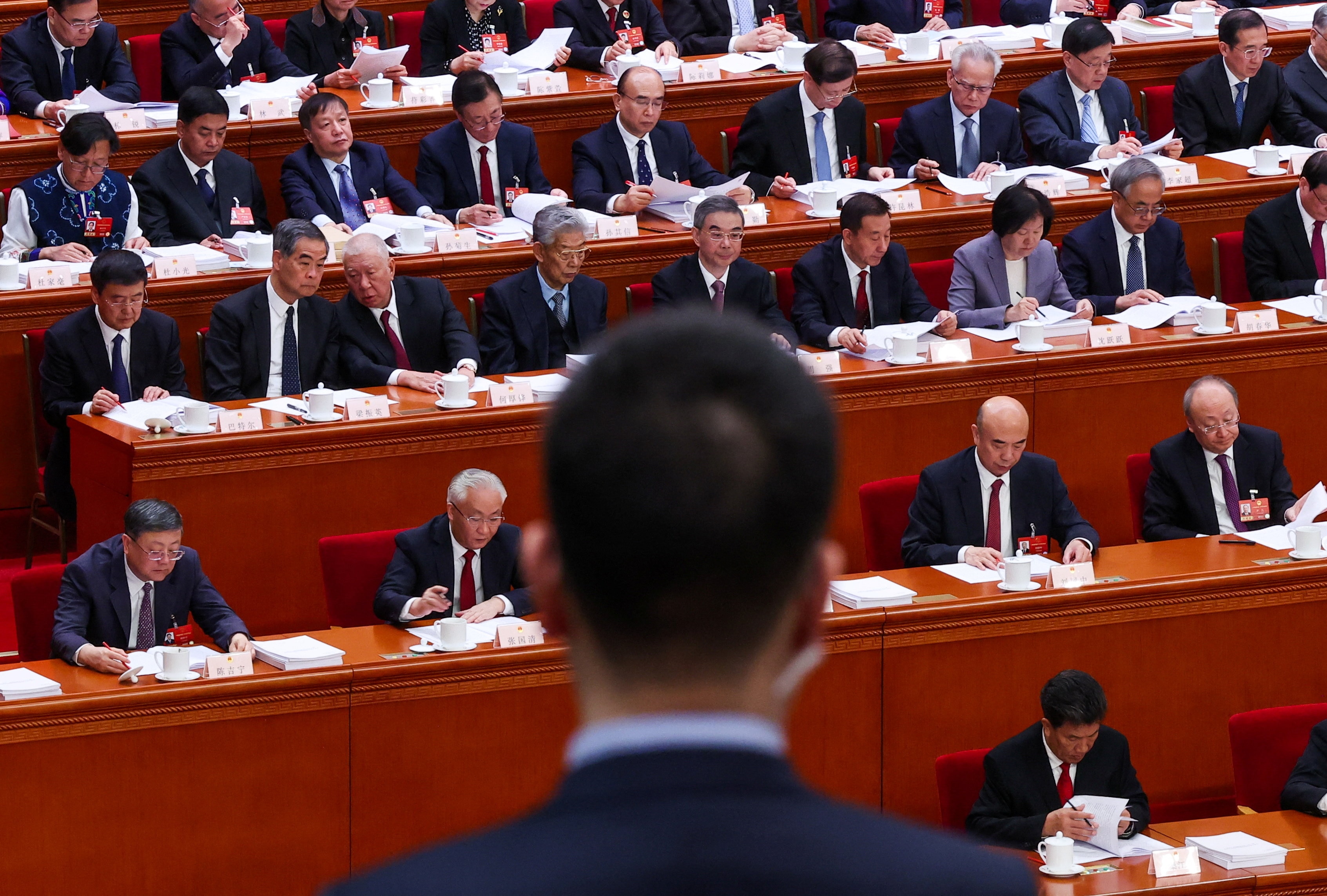 Men sitting in pews look on at the red Great Hall.