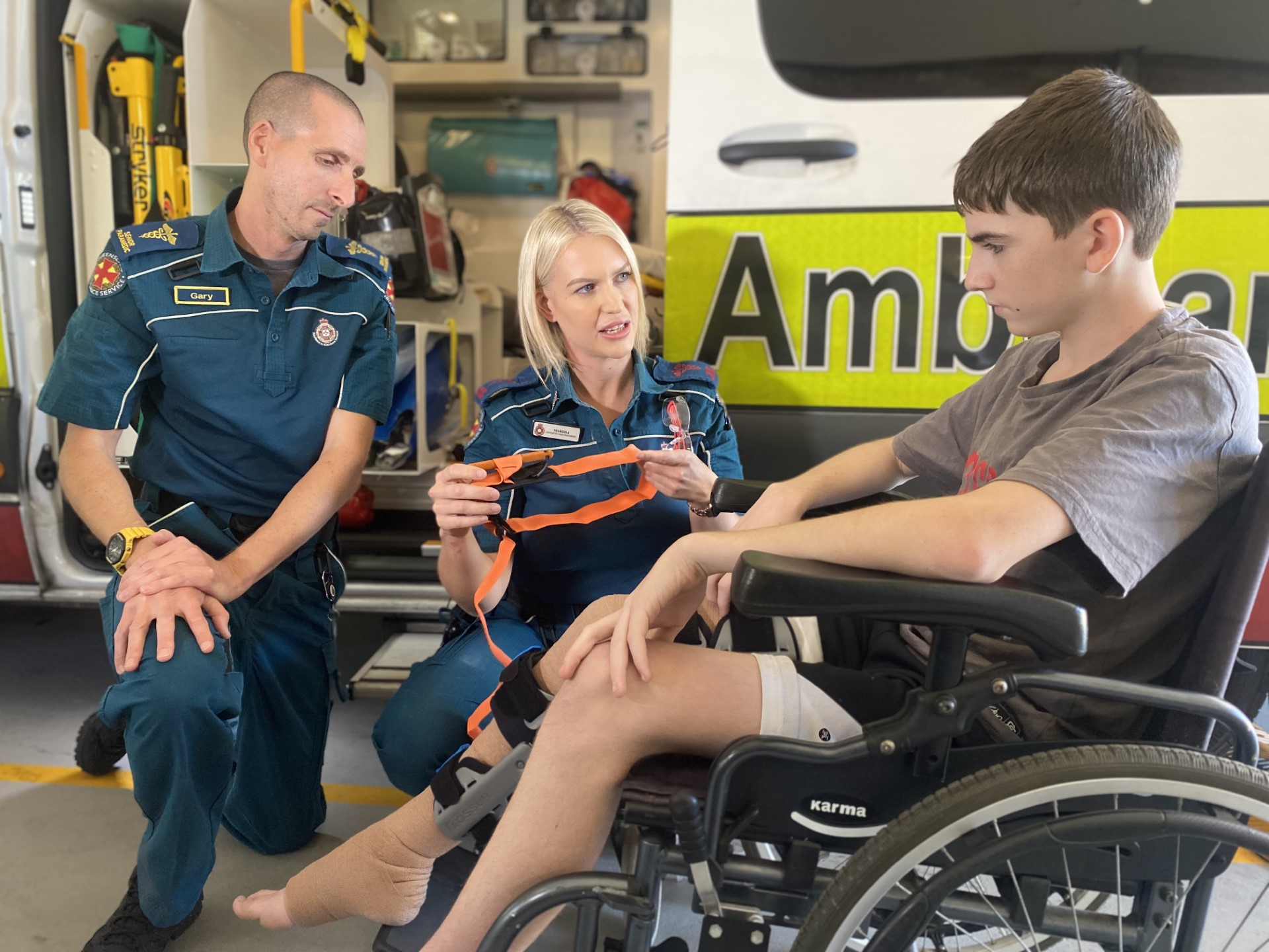 paramedics with teenage boy in wheelchair