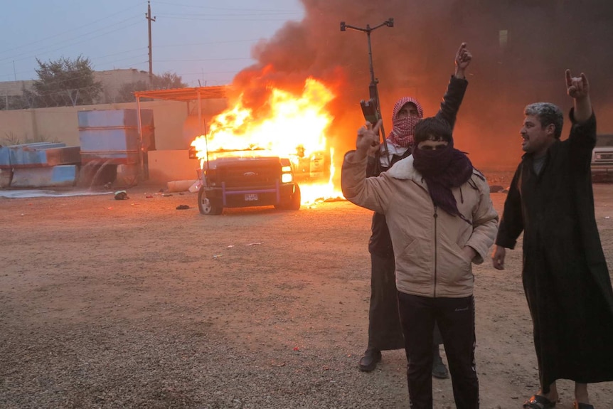 Islamic insurgents burn a police vehicle in Ramdi, Iraq.