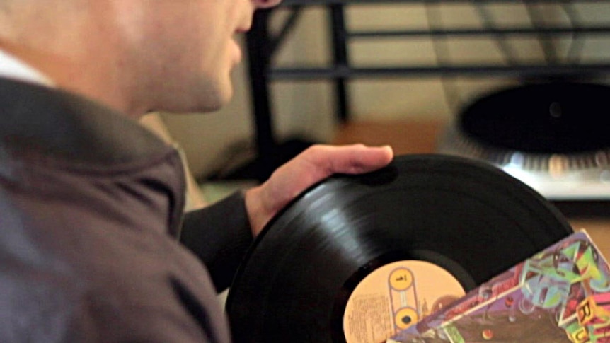 A man removes an LP from its sleeve.