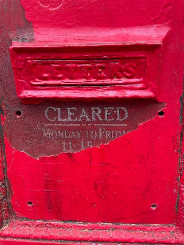 Sob uma camada de tinta vermelha, é revelado um cronograma de limpeza da caixa de correio.