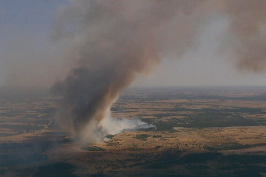 Aerial shot of smoke billowing across a rural landscape