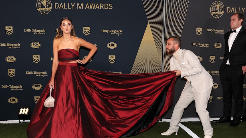 Penrith Panthers captain Isaah Yeo stands off to the side while partner Ashley Camenzuli gets her train adjusted at the Dally M.