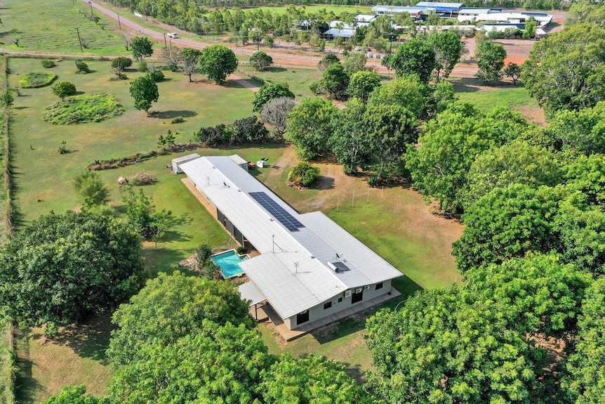 An aerial view of a long, rectangular-shaped surrounded by an expanse of green space and trees.