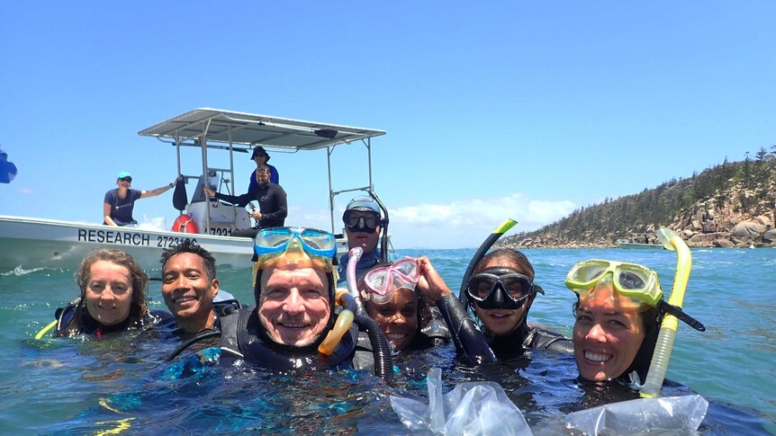 Peter Harrison in the ocean with a team pose for a selfie