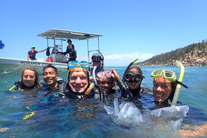 Peter Harrison in the ocean with a team pose for a selfie