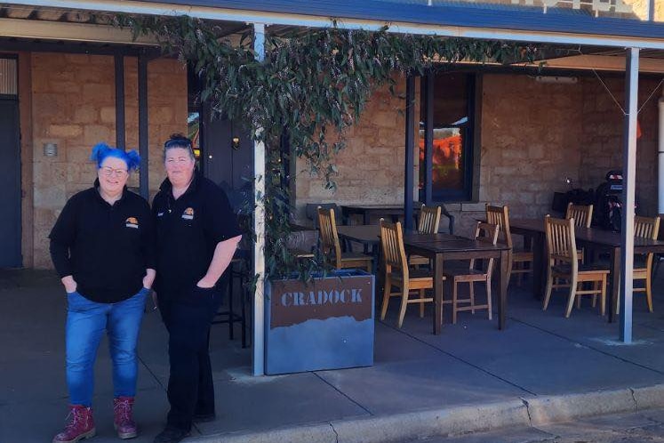 Two women standing in front of an outback hotel.