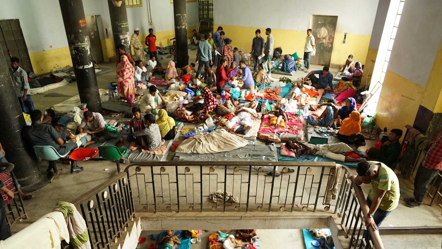 Scores of injured refugees lie on the hospital floor on makeshift beds.