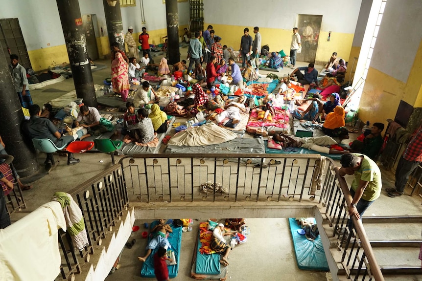 Scores of injured refugees lie on the hospital floor on makeshift beds.