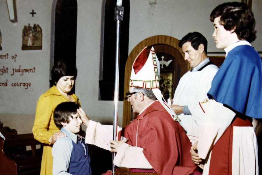 A grainy photograph of a young boy at a confirmation.