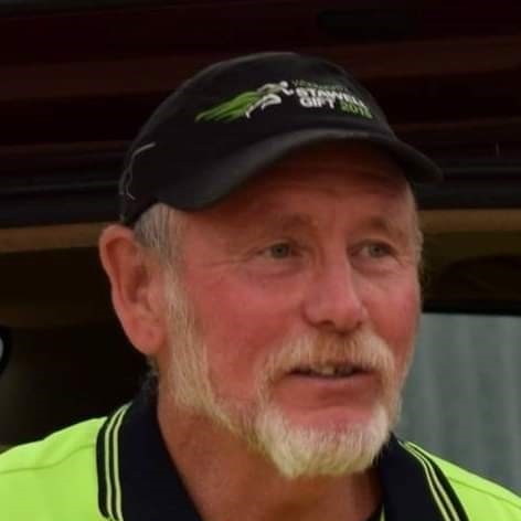 A man in a yellow fluro jumper wearing a black cap with the Stawell Gift logo on it