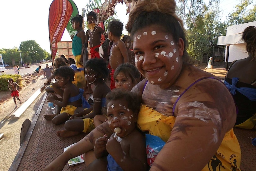 Indigenous people with faces painted at Boab Festival Mardi Gras float parade