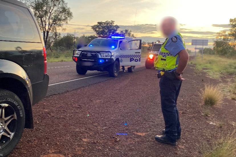 A Kununurra police officer stands on the side of the highway at the traffic stop where Mr Smith was made to pull over.