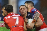 A Canberra Raiders NRL player is tackled by two St George Illawarra opponents.
