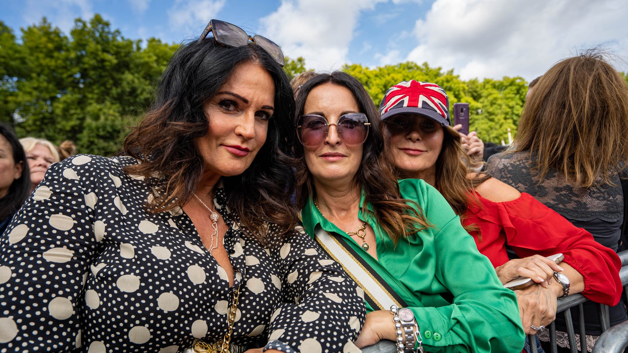 Three women pose together 