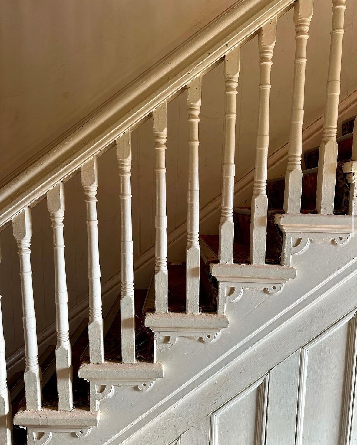 A close up of a carved wood balustrade on a staircase 