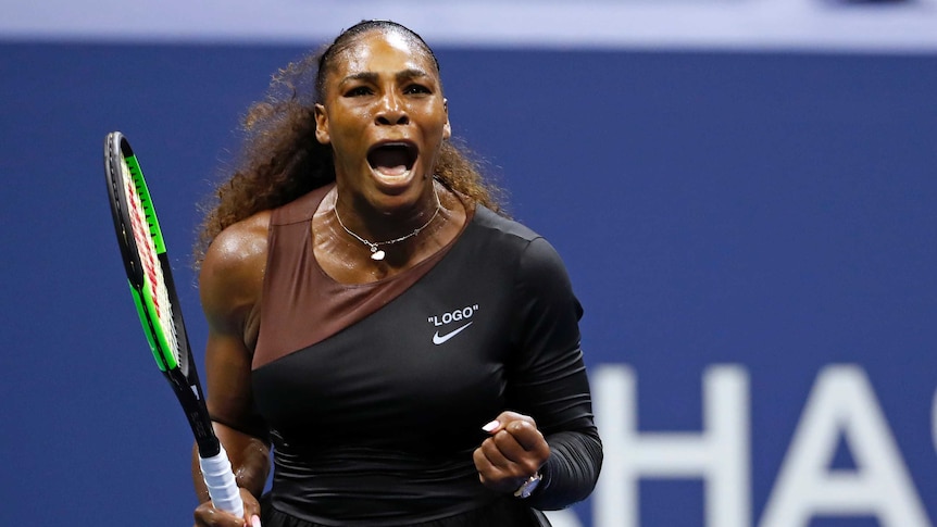 Serena Williams pumps her fist and screams out to celebrate winning a point.