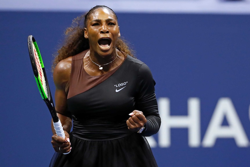 Serena Williams pumps her fist and screams out to celebrate winning a point.