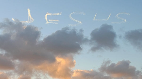 A skywriter adds 'Jesus' to the sunset panorama in Sydney