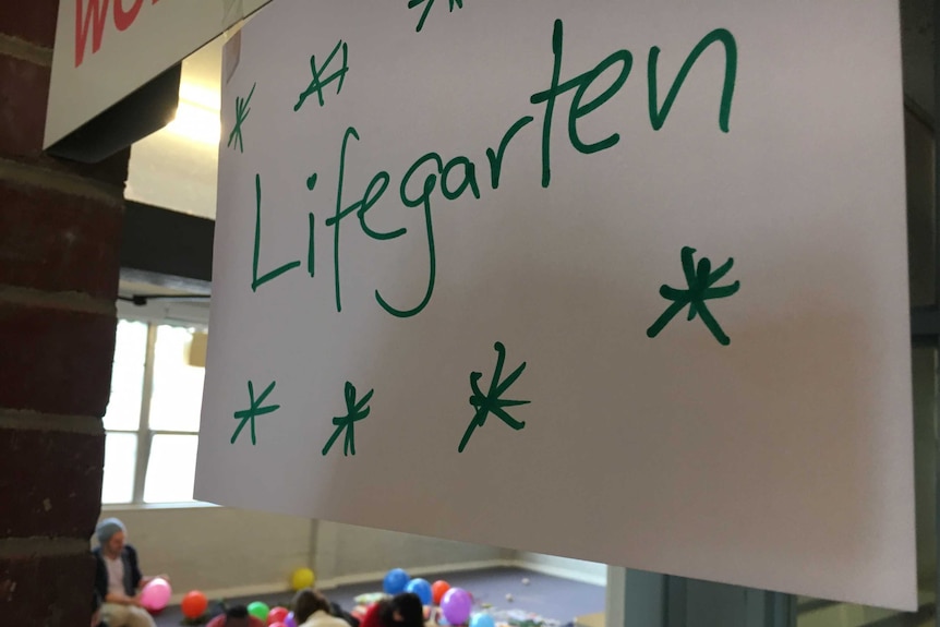A sign with the world 'lifegarten' hangs above a door