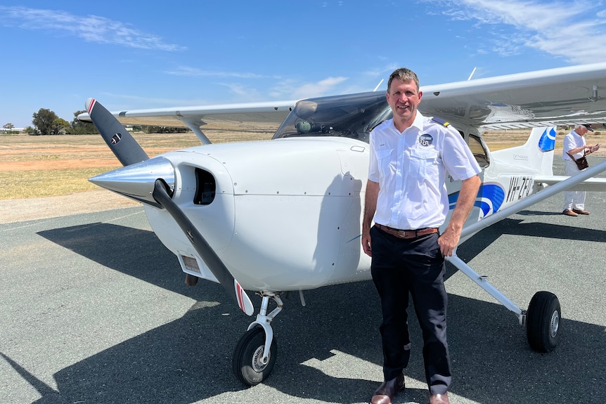 Peter McDonald stands in front of a small white plane