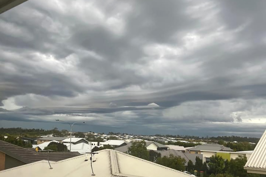 Storm clouds over a line of suburban rooftops