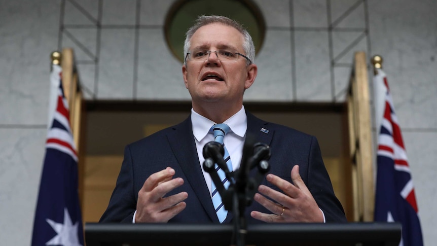 Scott Morrison announces his new ministry speaking with Australian flag behind