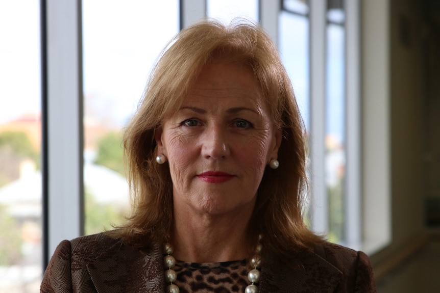 A woman in headshot in front of a window.