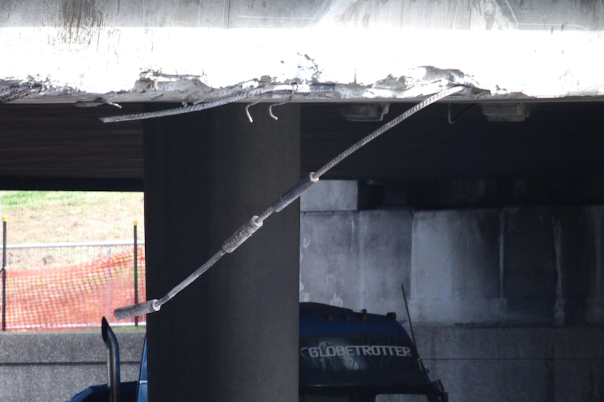 An image of the damage to the Hay Street overpass, showing ripped concrete and hanging steel bars.