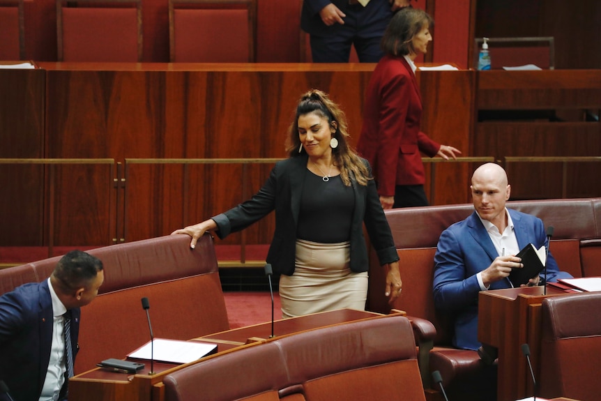 Thorpe smiles as she prepares to take a seat next to Senator Ralph Babet in the Senate.