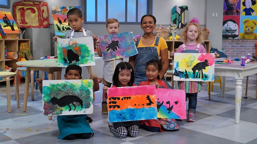 Zindzi with children who are holding up their artwork