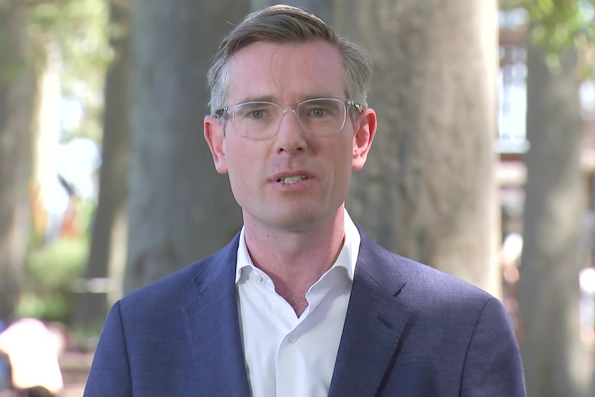 a man wearing glasses looking and talking