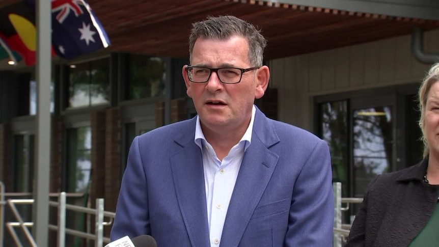 Premier Daniel Andrews wearing a blue suit and glasses.