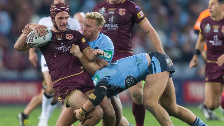 Kalyn Ponga is tackled by the New South Wales Blues in State of Origin II.