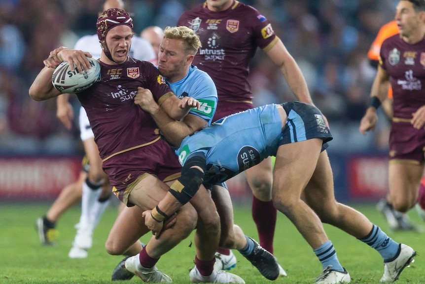 Kalyn Ponga is tackled by the New South Wales Blues in State of Origin II.