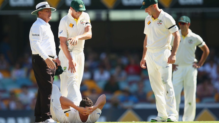 Testing day ... Peter Siddle stretches the leg of team-mate Josh Hazlewood
