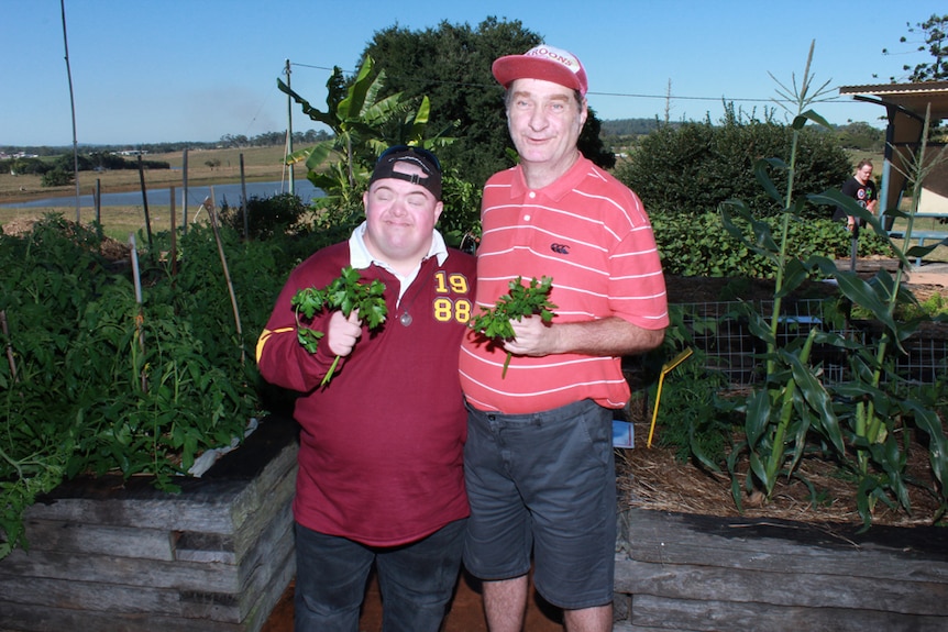 two men holding herbs and smiling
