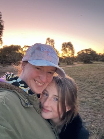 A 13-year-old girl and her mum selfie in front of a sunset.