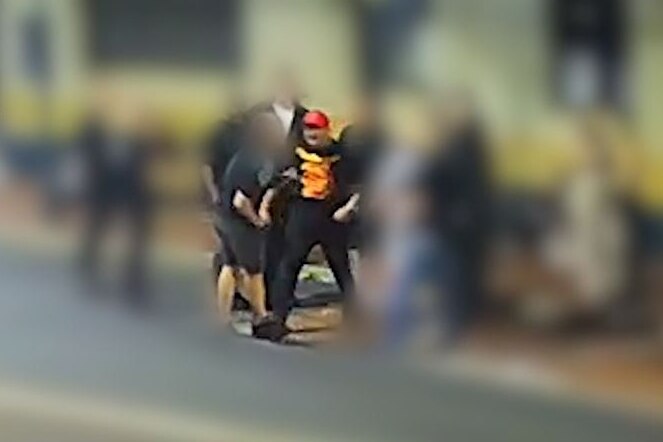 CCTV of a man in a red hat about to punch another man.