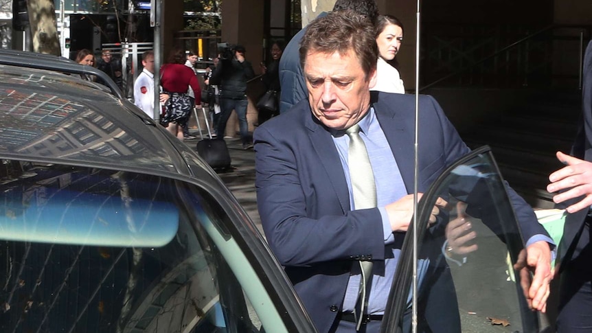 Mark 'Bomber' Thompson, dressed in a suit, gets into a car.