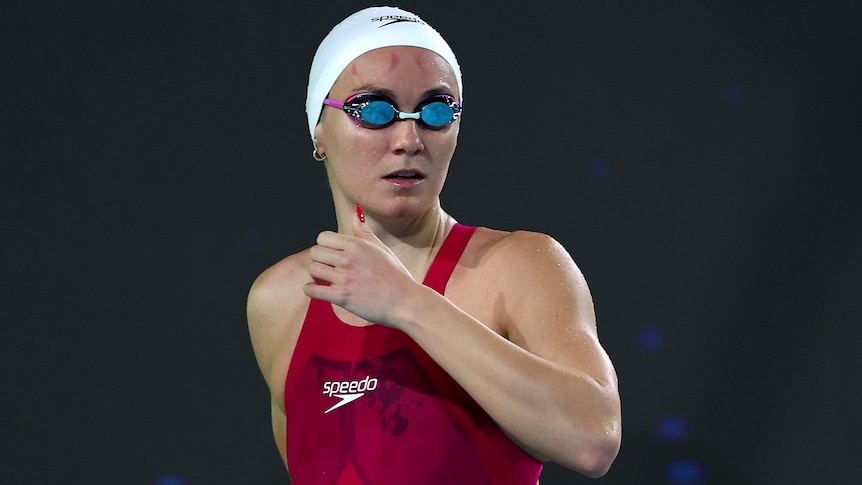 Ariarne Titmus looks towards the pool while wearing goggles at the Australian Olympic swimming trials.
