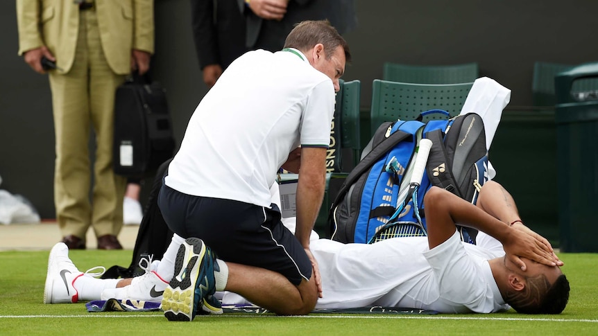 Nick Kyrgios receives medical attention at Wimbledon