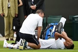 Nick Kyrgios receives medical attention at Wimbledon