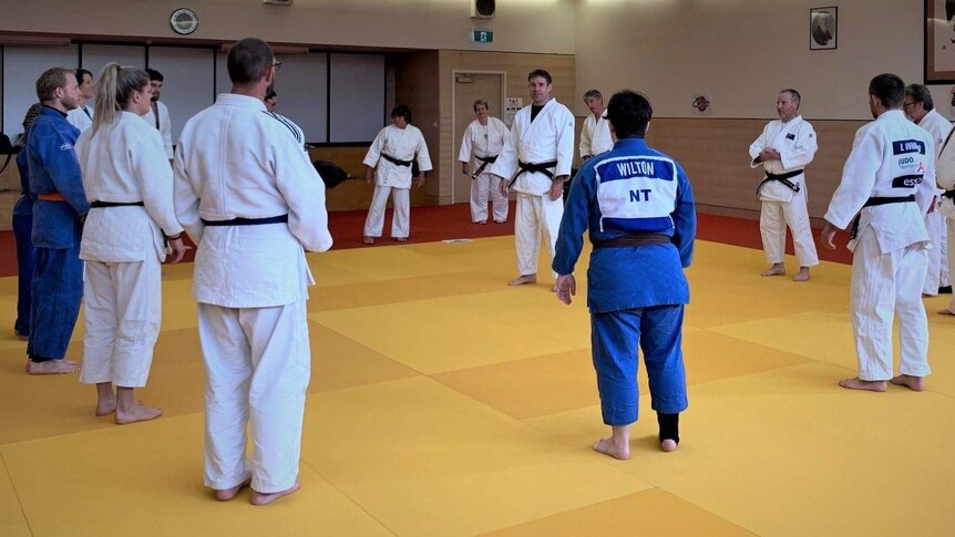 People in a circle at a judo training session.