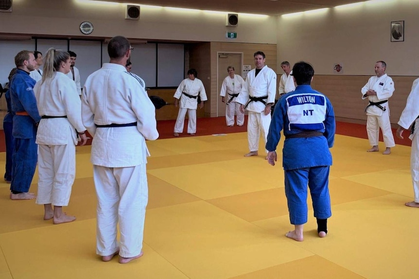 People in a circle at a judo training session.