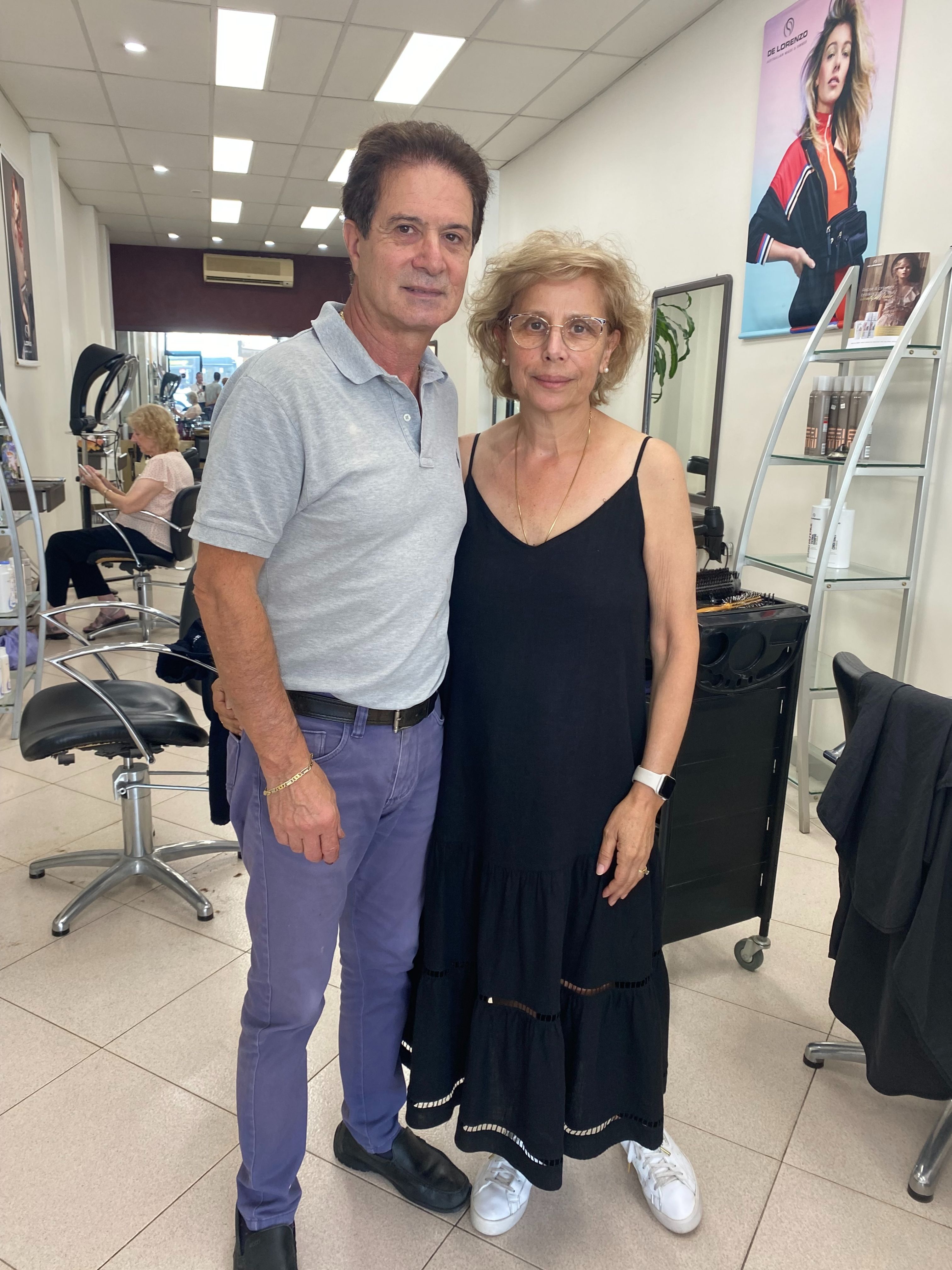 A man and a woman stand in a hair salon.